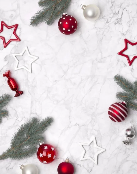 Kerangka komposisi Natal yang terbuat dari cabang-cabang cemara, pernak-pernik, permen dan bintang-bintang pada latar belakang marmer putih — Stok Foto