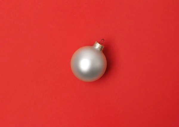 Bola de Navidad blanca sobre fondo de papel rojo . — Foto de Stock