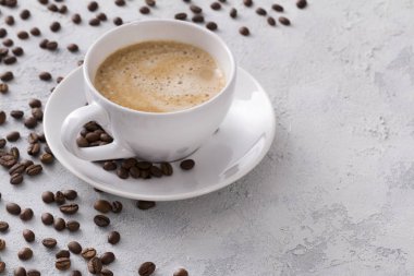 Gri bir beton t lezzetli sıcak kapuçino ve fasulye bir fincan