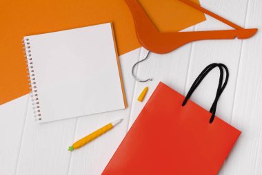 Not defteri, kalem ve beyaz üzerinde askı ile Turuncu kağıt alışveriş çantası