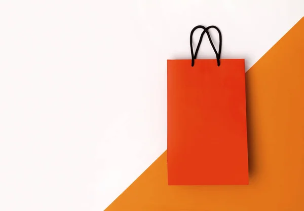 Orange paper shopping bag with black handles on the white backgr — Stock Photo, Image