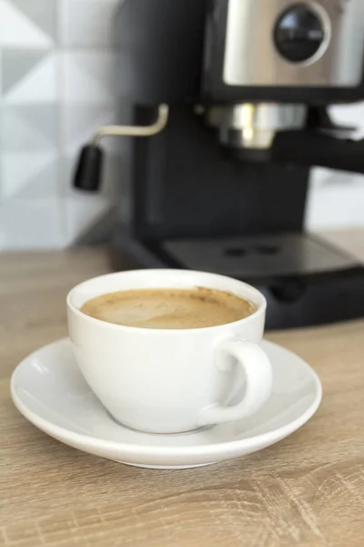 Coffee in white cup with coffee machine at the kitchen