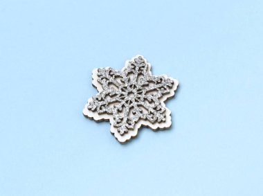 Mavi pastel arka plan üzerinde ahşap ışıltılı kar taneleri.