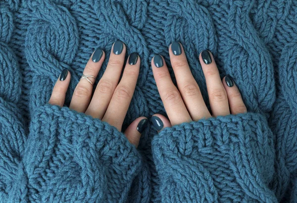 Manicured woman's hands in warm wool turquoise sweater — Stock Photo, Image