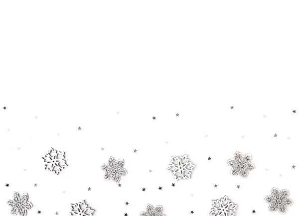 Silver wooden snowflakes and confetti on white background — 图库照片