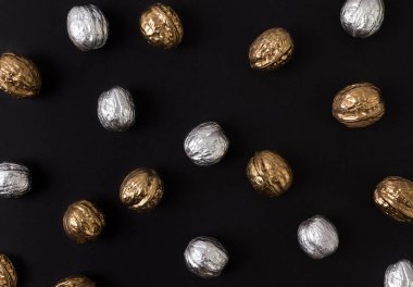 Siyah arka planda boyanmış altın ve gümüş cevizler