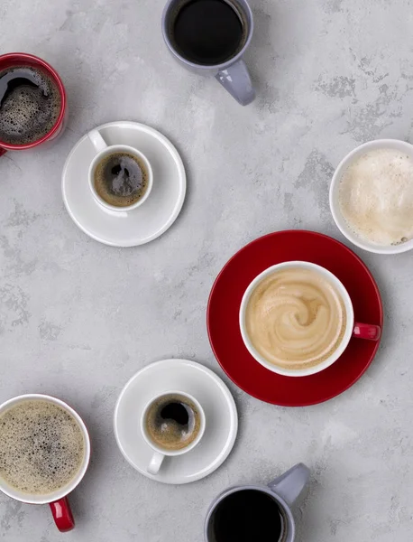 Divers café dans différentes tasses sur le fond gris béton — Photo