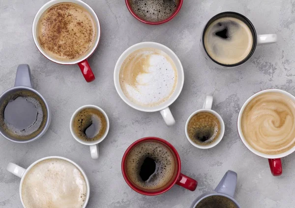 Różne kawy w różnych filiżanek na betonowym szarym tle — Zdjęcie stockowe