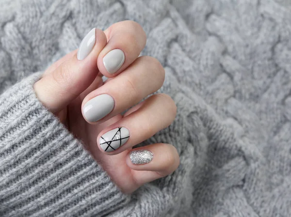 Mano de las hembras en suéter de punto gris con manicura moderna de cerca — Foto de Stock