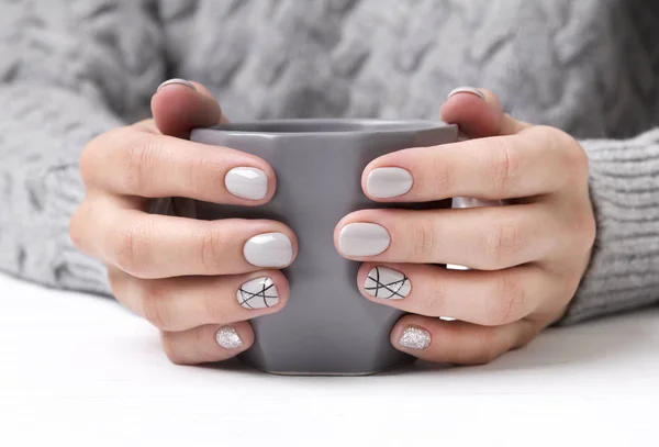 Woman's hands with geometric manicure nail design in cozy sweater — Zdjęcie stockowe