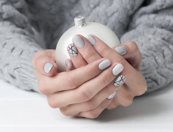 Manos de mujer con diseño de uñas de manicura geométrica en suéter acogedor — Foto de Stock