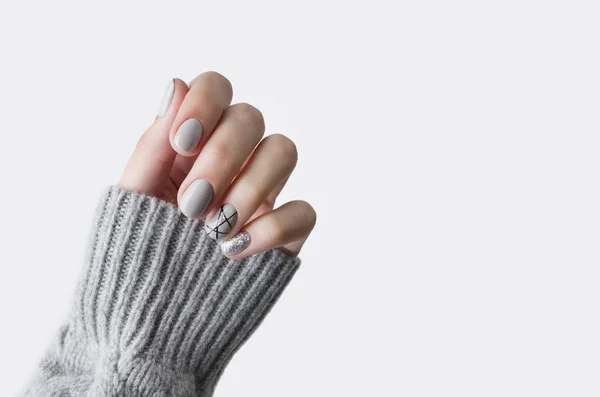 Mano de las hembras en suéter de punto gris con manicura moderna de cerca — Foto de Stock