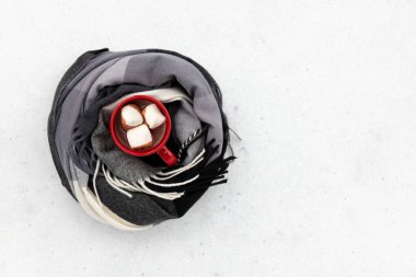 Gri arka planda eşarba sarılı sıcak kakaolu kırmızı bardak. Düz görünüm sonbahar kış kompozisyonu yatıyordu. 