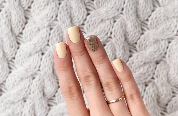 Manicured womans hands with warm wool beige sweater — Stock Photo, Image