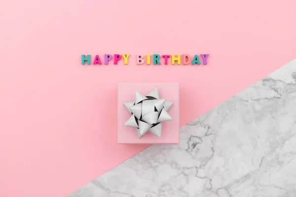 来自木制彩信和礼品盒的生日快乐题词 粉色和大理石背景的生日海报模板 — 图库照片