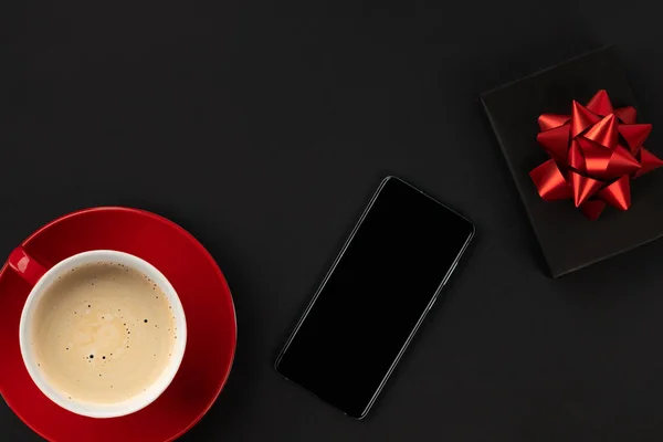 Creativo plano laico superior ver composición smartphone, taza de café y regalo — Foto de Stock