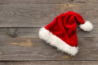 Kırmızı Noel Baba şapkası eski ahşap arka planda