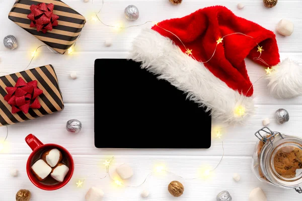 Tableta digital con chocolate caliente y regalos sobre fondo de madera blanca — Foto de Stock