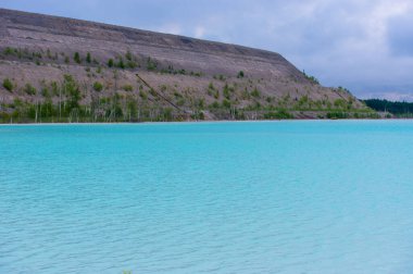 Turkuaz göl dramatik kireçtaşı uçurumları ve huş ağaçlarıyla çevrili. Bulutlu bir gökyüzünü yansıtan kristal berrak suyla el değmemiş kuzey doğası.