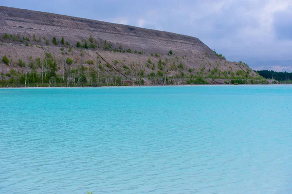 Turkuaz göl dramatik kireçtaşı uçurumları ve huş ağaçlarıyla çevrili. Bulutlu bir gökyüzünü yansıtan kristal berrak suyla el değmemiş kuzey doğası.