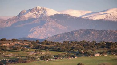 Madrid 'i çevreleyen karlı dağların manzarasında Sierra de Guadarrama Ulusal Parkı ve Cuenca Alta del Manzanares Bölgesel Parkı yer almaktadır.