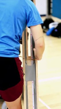 A wheelchair boccia instructor adjusts the ramp for optimal ball release, showcasing the precision needed in this inclusive sport designed for individuals with cerebral palsy.