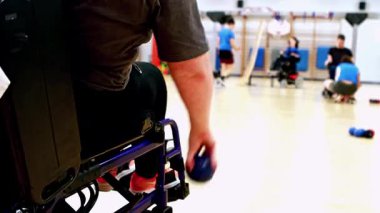 Athletes with cerebral palsy engage in a lively wheelchair boccia sport in a modern sports facility, showcasing skill and strategy in this inclusive and competitive sport.