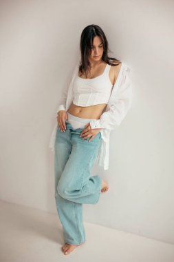 Stüdyodaki genç bayan düşünceli ve neşeli bir ruh hali içinde. Kadın karakteri.