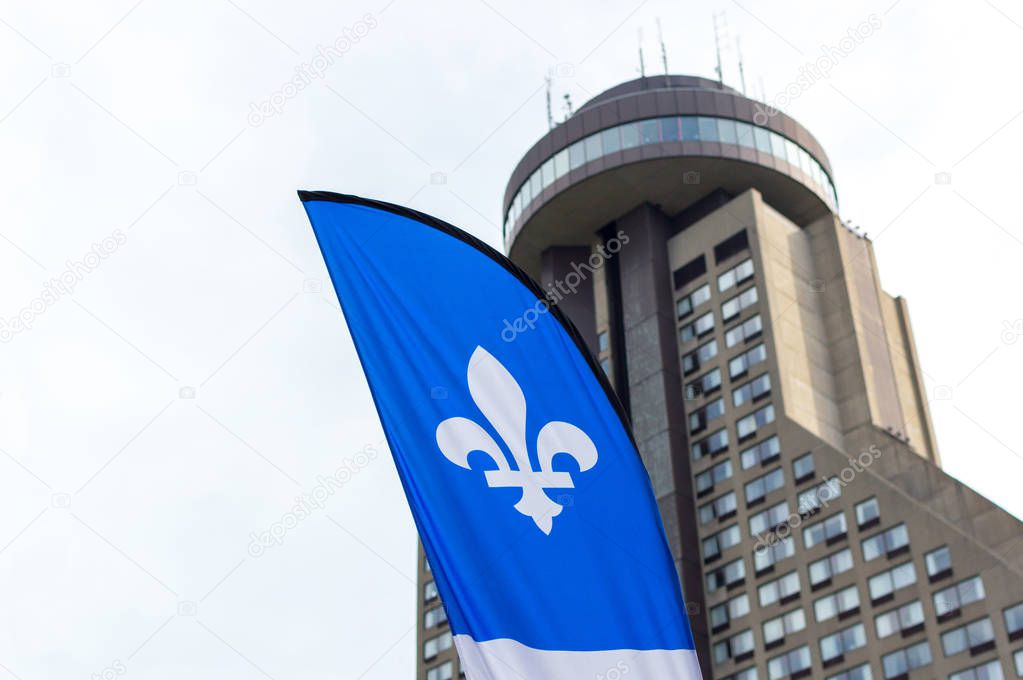 Quebec flag and Hotel Le Concorde view in summer sunny blue sky