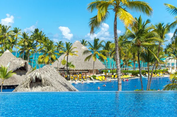 İnsanlar ve Punta Cana beldesinde palmiye ağaçları arasında Bungalov.