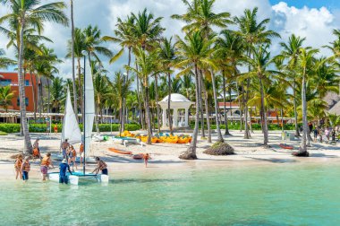 Punta Cana, Dominik Cumhuriyeti - 26 Ekim 2018: İnsanlar plajda Punta Can beldesinde palmiye ağaçları arasında sakin ol