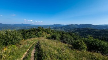 Dağları ve mavi gökyüzü olan güzel bir manzara.