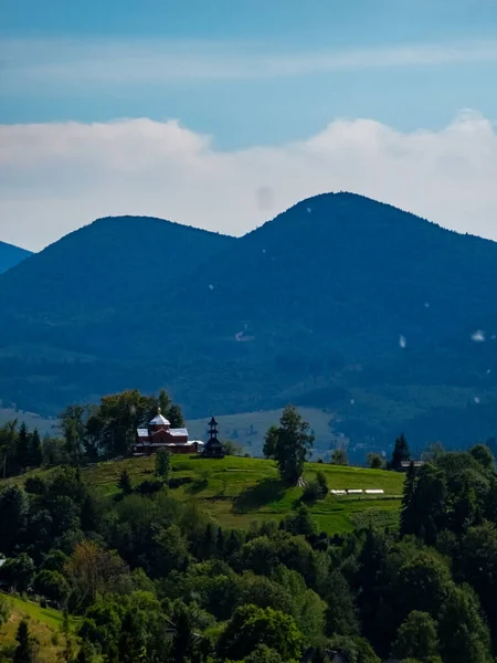 Dağlarla çevrili yeşil bir tarlanın güzel bir görüntüsü.