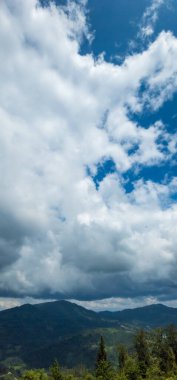 Dağları ve mavi gökyüzü olan güzel bir manzara.