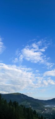 Bulutları ve mavi gökyüzü olan güzel bir manzara.