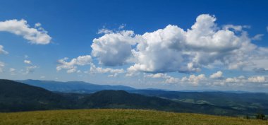 Dağları ve mavi gökyüzü olan güzel bir manzara.