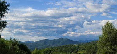 Dağları ve mavi gökyüzü olan güzel bir manzara.