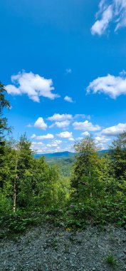 Dağları ve mavi gökyüzü olan güzel bir manzara.