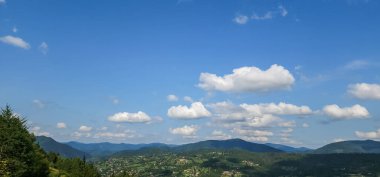 Dağları ve mavi gökyüzü olan güzel bir manzara.