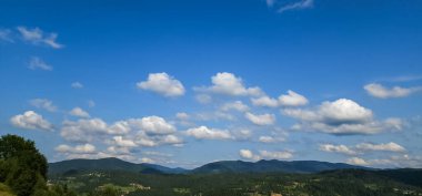 Arkaplanda dağlar olan mavi bulutlu gökyüzü