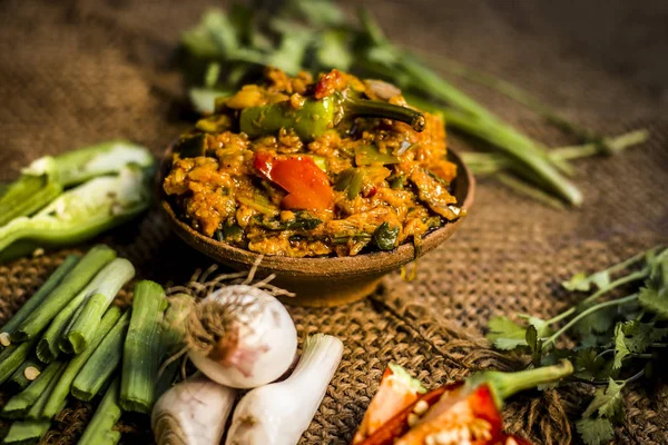 Hint ile sebze benzeri: taze soğan, kış sezonu Baingan ka Bharta yenen yemeğin yakın Allium fistulosum, kişniş, Coriandrum sativum, sarımsak, Allium sativum ve titreme.