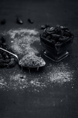 Onun tozu ile mavimsi bir yüzey üzerinde ham siyah kakule.;