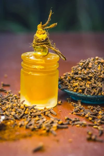 Close up of clove with its oil and powder in a white fork.