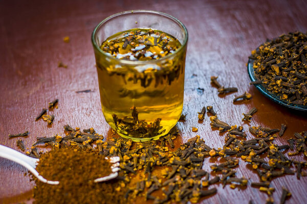 Крупный план гвоздики в пластине с ее порошком в вилке и водой в прозрачном стекле
.