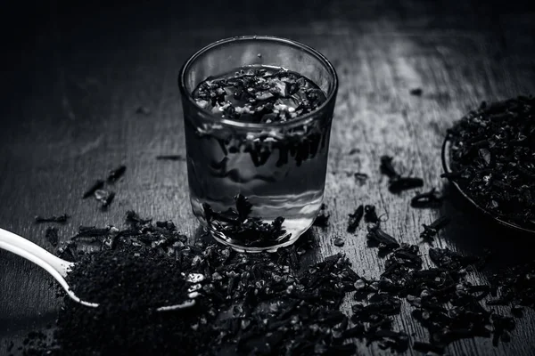 Bir çatal onun tozu ve şeffaf bir bardak su ile bir tabak içinde diş görünümünü kapat.