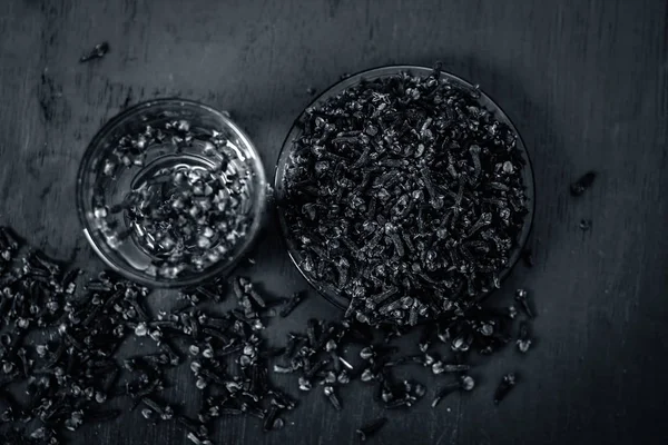 Karanfil bir plaka ve şeffaf bir bardak suda görünümünü kapat