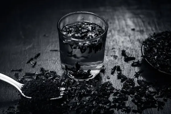 Bir çatal onun tozu ve şeffaf bir bardak su ile bir tabak içinde diş görünümünü kapat.