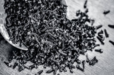 Ahşap yüzeyde bir kil kase ham organik karanfil.