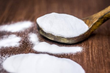 Ahşap yüzey üzerinde tahta bir kaşık kabartma tozu