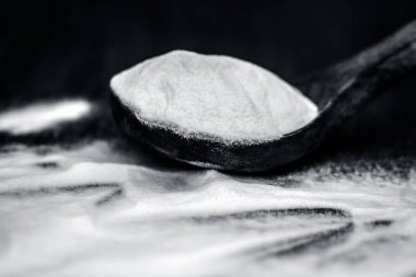 Ahşap yüzey üzerinde tahta bir kaşık kabartma tozu